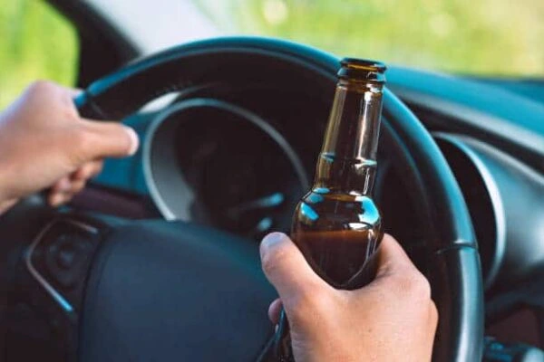 Driver holding a beer while steering, illustrating possible mid range PCA