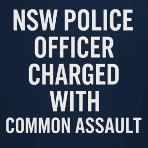 Text graphic reading “NSW Police Officer Charged with Common Assault” in bold white capital letters on a dark blue background.